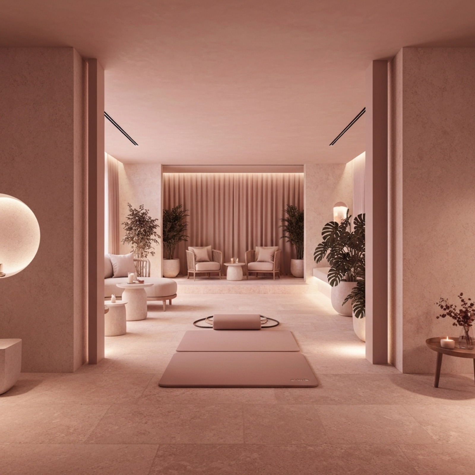 A blush plaster lounge with soft chairs, candles and a meditation mat